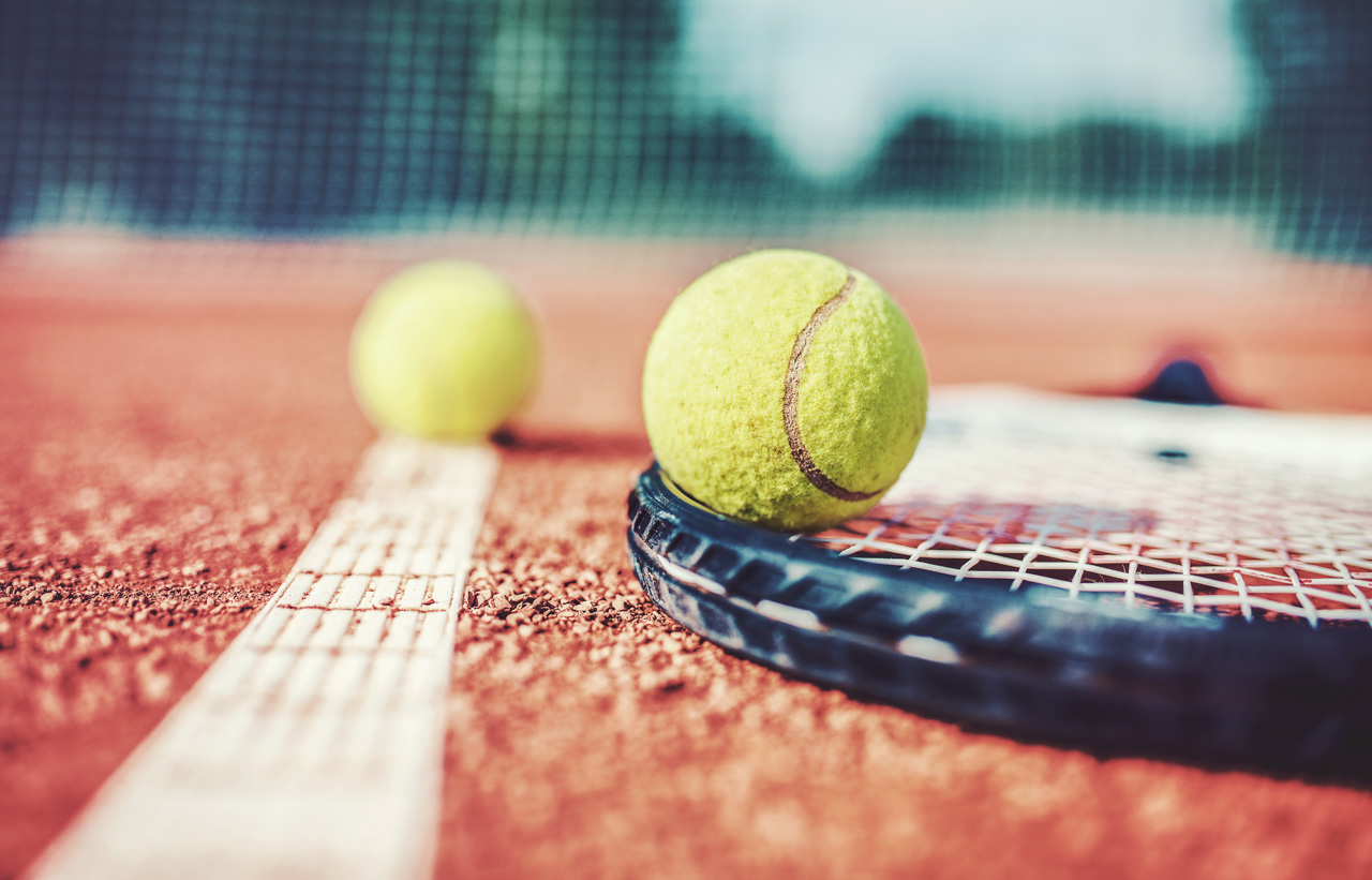 Tennis ball with racket on the tennis court. Sport, recreation concept